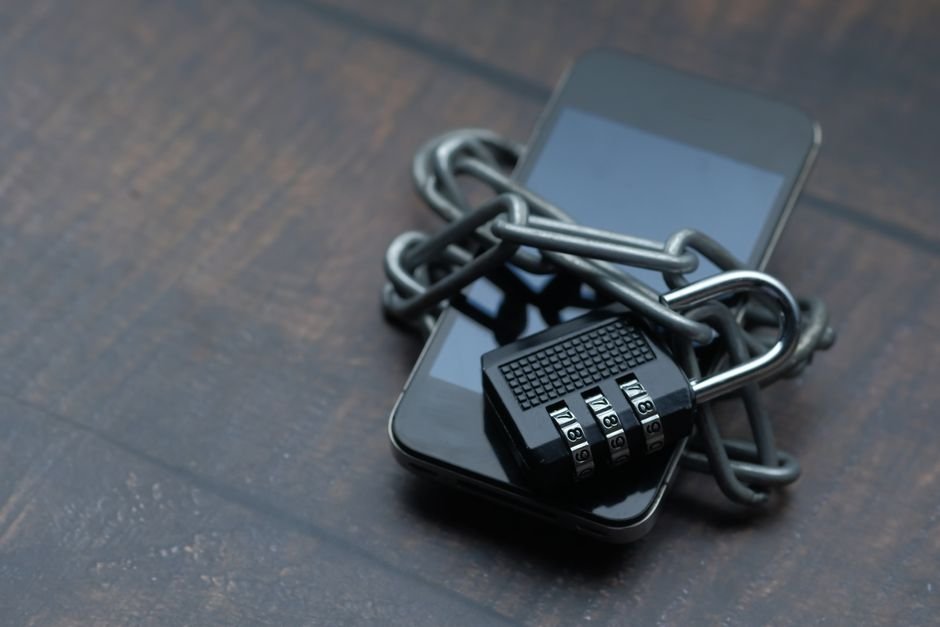 AegisAI lève 36 millions de dollars pour combattre le phishing par IA Smartphone entouré d'une chaîne avec un cadenas, symbole de cybersécurité contre le phishing par IA