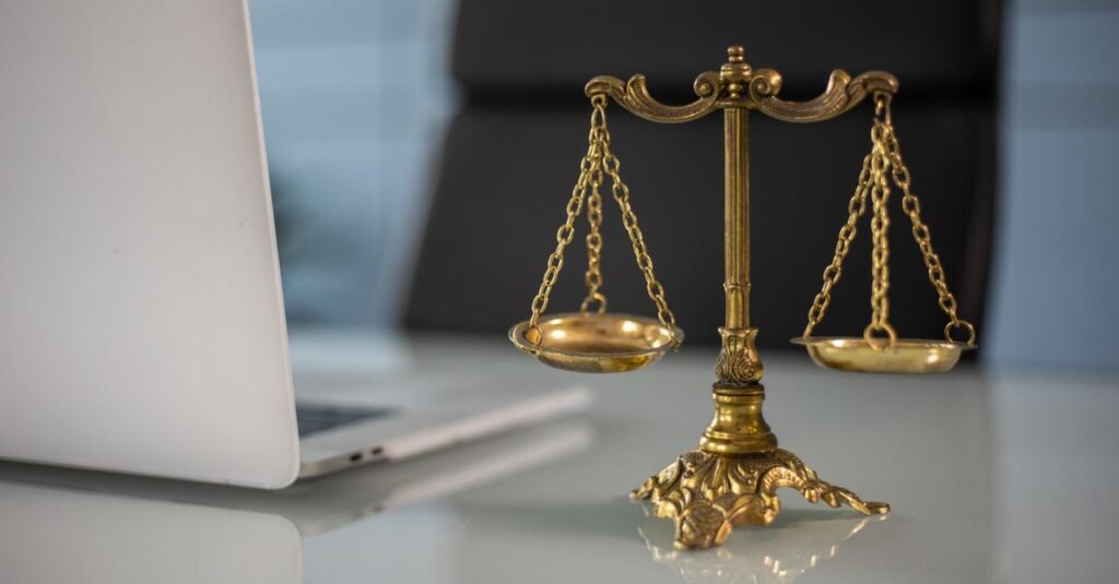 Allemagne : Google et Perplexity visés par une régulation médias IA inédite Balance de la justice dorée posée à côté d'un ordinateur portable, symbolisant la régulation juridique de l'IA