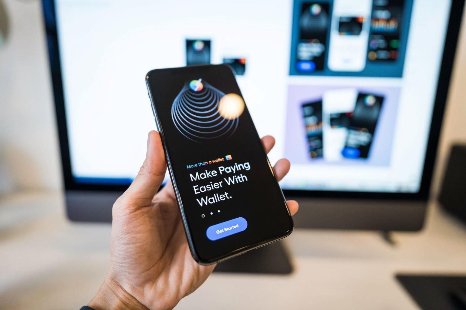 Main tenant un smartphone affichant une application de portefeuille numérique, illustrant Cloudflare Wallets pour les agents IA