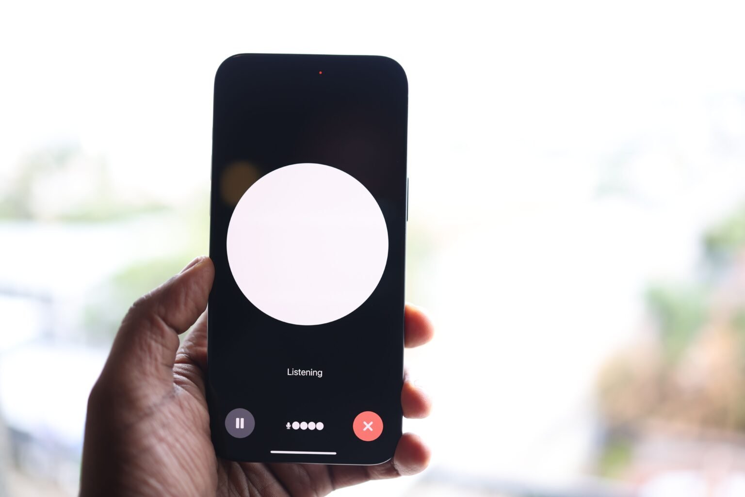 Personne tenant un smartphone avec une interface d'assistant vocal IA