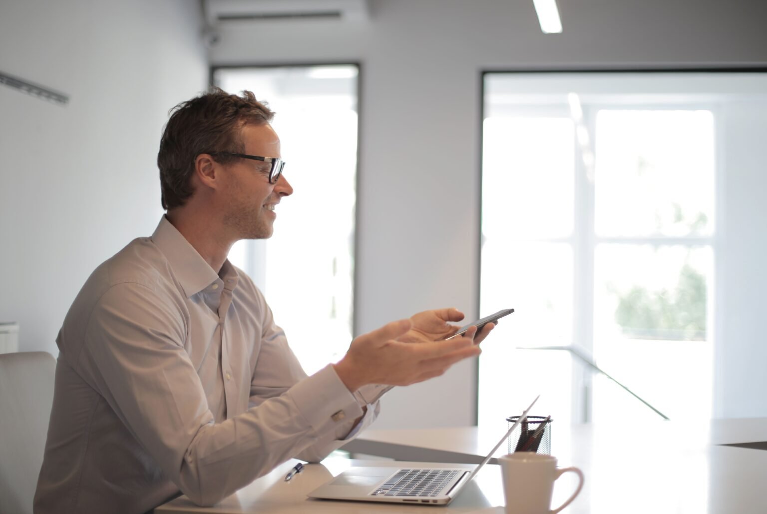 Salarié utilisant un smartphone et un ordinateur au bureau, illustrant le shadow AI en entreprise