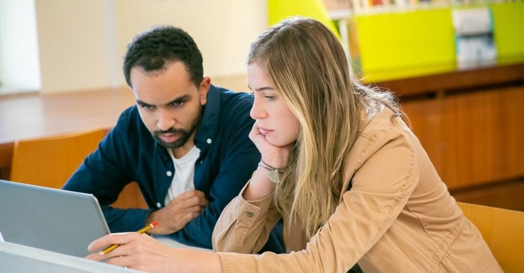 Étudiants d'université passant un examen en ligne sur ordinateur portable
