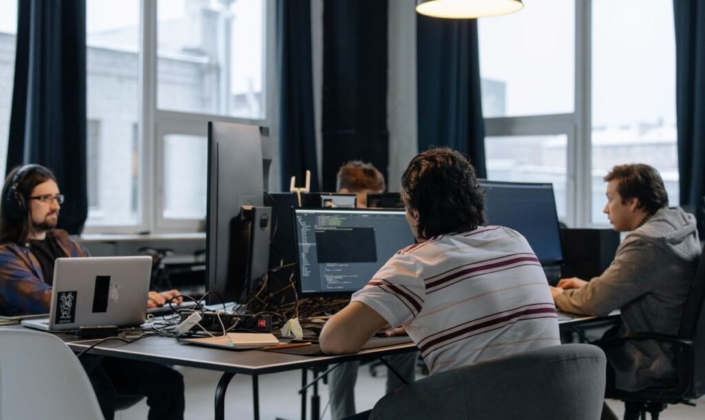 Team of developers collaborating on computers in a modern office, Claude Tag projects